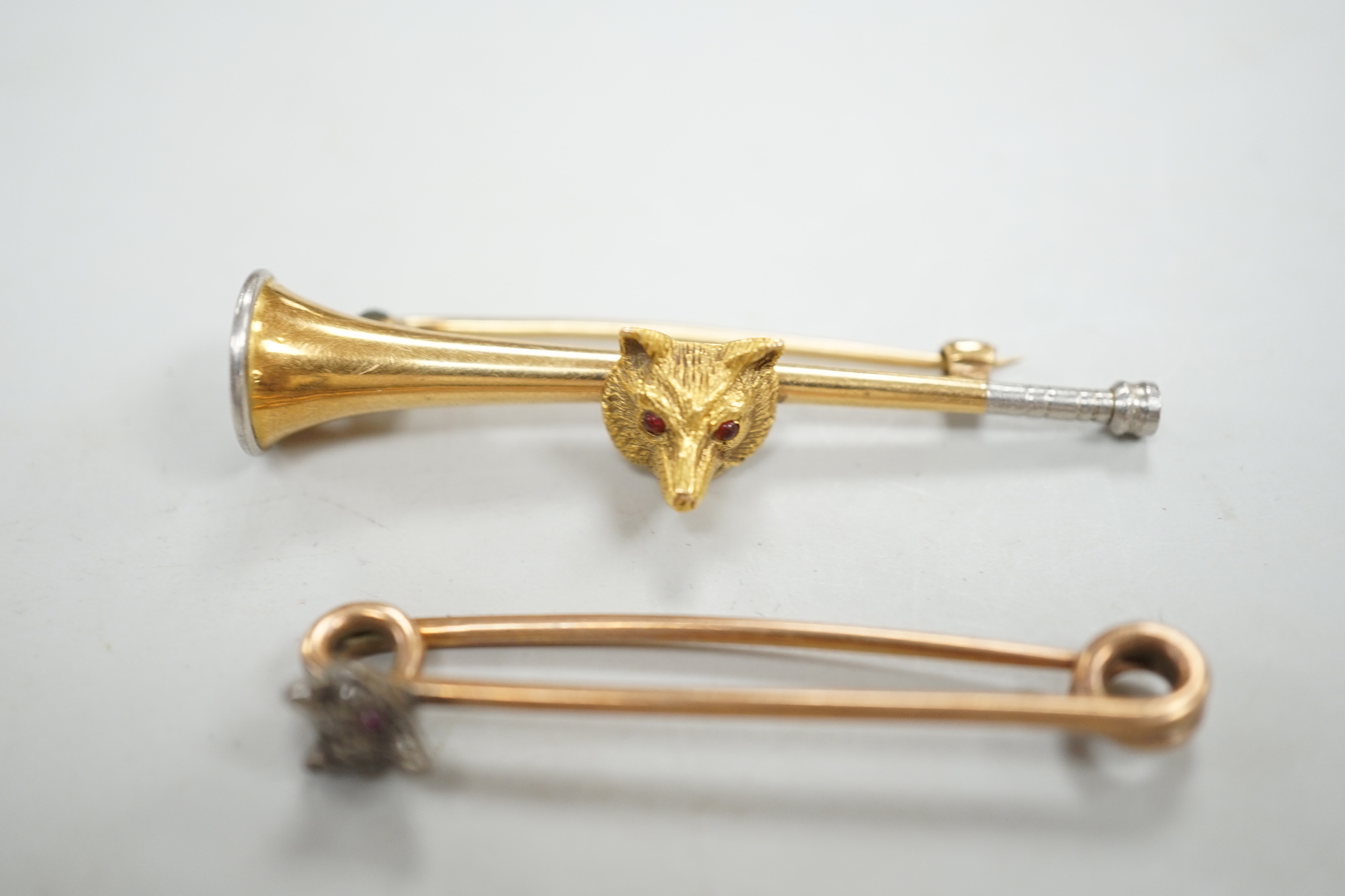 A Victorian yellow metal and diamond cluster set fox head pin, 44mm, two other fox head pins and a 15ct fox head and hunting horn brooch, gross weight 8.5 grams.
